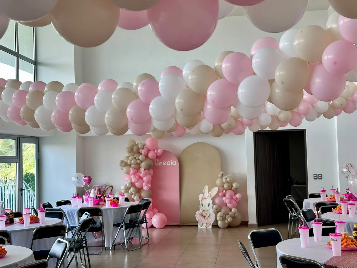Salón con decoración coordinada y globos pastel